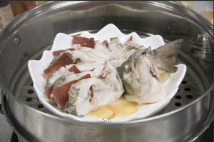 將鱸魚成花狀擺好，將火腿切片放入各縫隙中，放入鍋中隔水蒸12分鐘拿出，撒上蔥花即可。