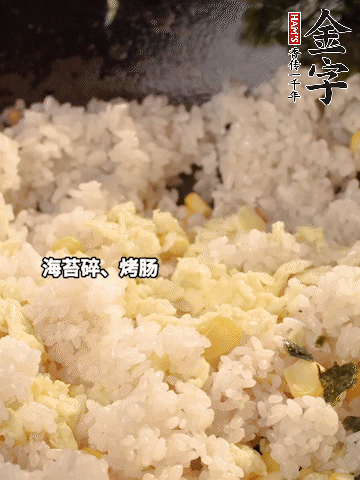剩米飯下鍋炒散，依次下玉米粒、雞蛋、烤腸、海苔碎翻炒均勻。