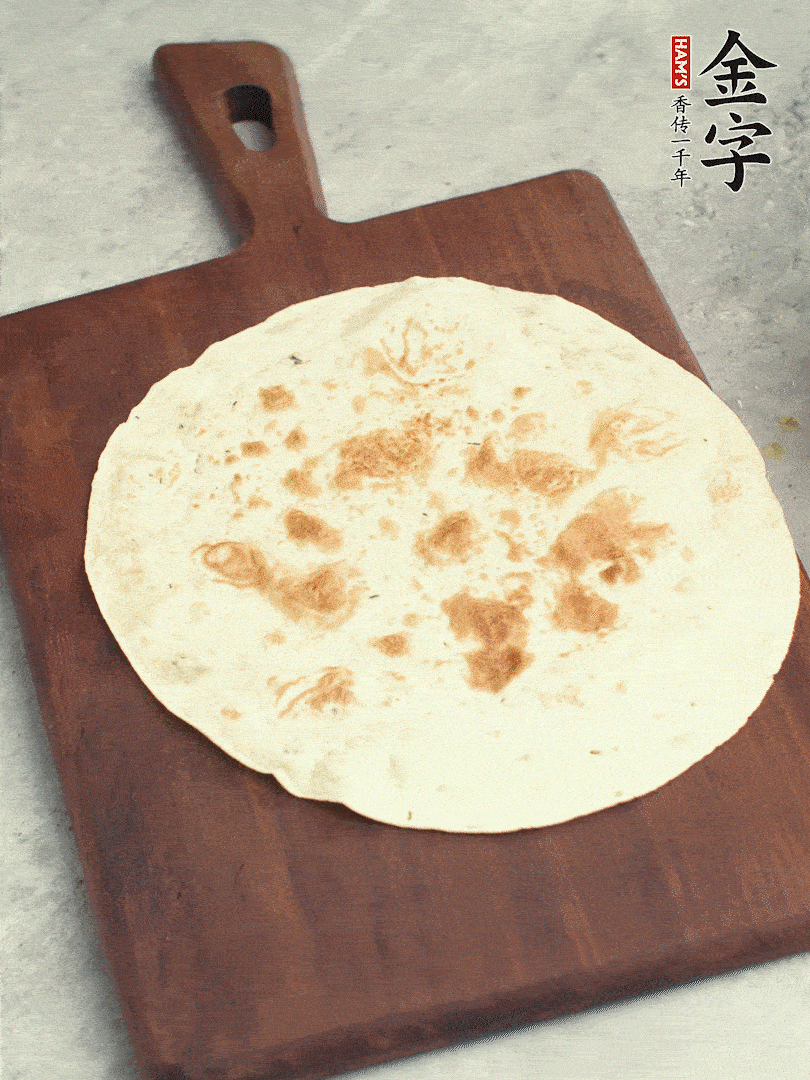 食材依次鋪在卷餅皮上，卷起來。