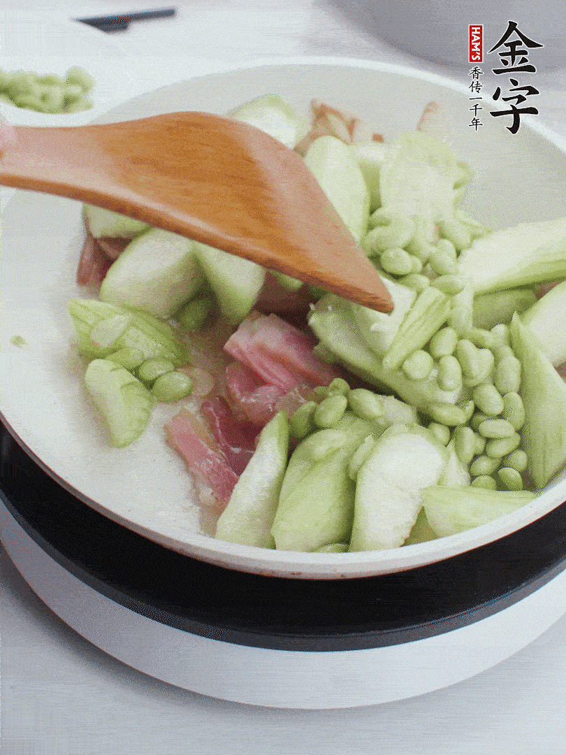 依次下絲瓜、青豆翻炒，炒至絲瓜打蔫縮小。