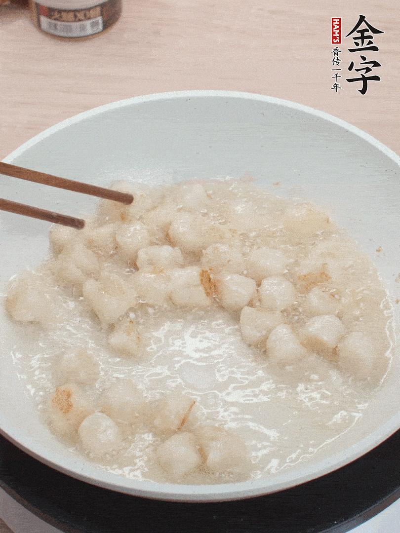 油溫4成熱，鮮貝蘸干淀粉下鍋煎，一面微黃后翻面。