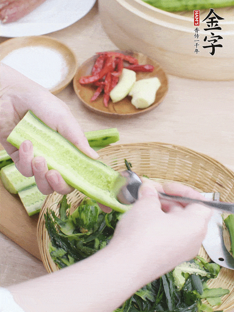 黃瓜削皮，對(duì)半切開(kāi)，勺子挖去內(nèi)瓤，斜刀切片。青蒜斜刀切段。