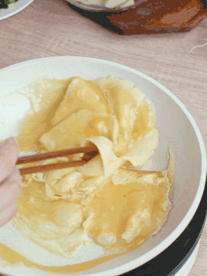油6成熱時(shí)，下雞蛋液，邊緣凝固時(shí)翻拌成塊狀。