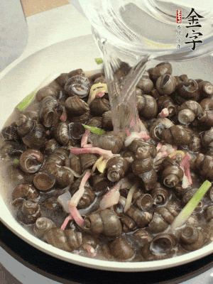 倒處理干凈的螺螄翻炒，加3勺料酒。加清水蓋過螺螄，中火蓋蓋煮5分鐘。