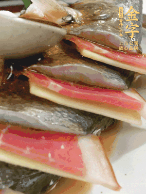 魚肚中塞蔥結(jié)、火腿片，魚身上碼放姜片、火腿片，倒入混合的料汁。